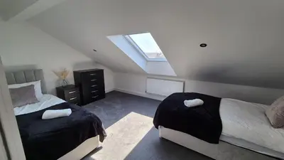 a attic bedroom with two beds and a skylight at Spacious & Modern house in St Helens in Saint Helens