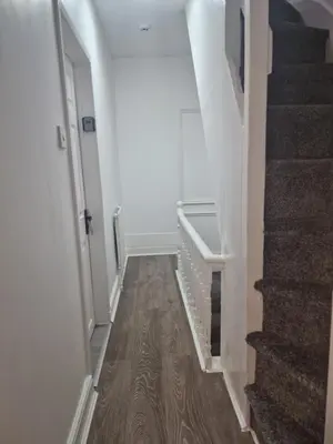 a hallway with a staircase with white walls and wood floors at Excellent Suite Room in Liverpool in Liverpool