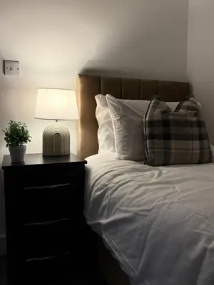 a bedroom with a bed with a lamp and a pillow at Comfortable and Modern Living house in St Helens in Saint Helens
