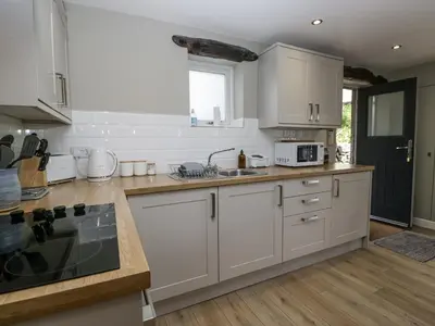 a kitchen with white cabinets and a sink at Threagill in Carnforth