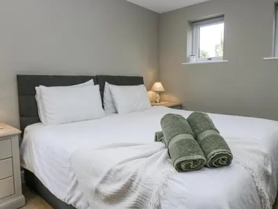 a bedroom with a white bed with towels on it at Threagill in Carnforth