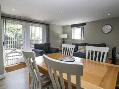 a dining room and living room with a table and chairs at Threagill in Carnforth