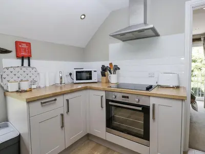 a kitchen with white cabinets and a stove top oven at Treacle in Carnforth