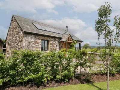 a stone house with solar panels on the roof at Lindeth Croft in Carnforth