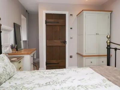 a bedroom with a bed and a wooden door at Lindeth Croft in Carnforth