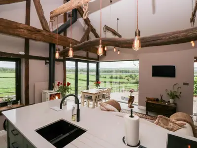 an open kitchen and living room with exposed beams at Lindeth Croft in Carnforth