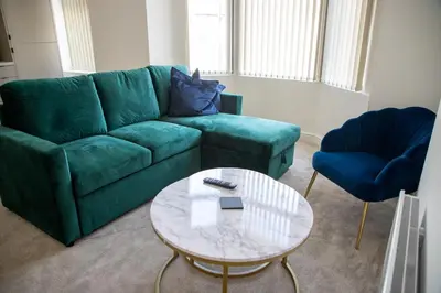 a living room with a green couch and a table at Balmoral Stays 4 - First Floor in Blackpool
