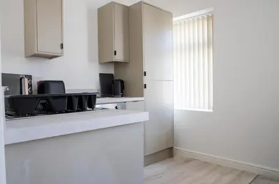 a kitchen with white cabinets and a counter top at Balmoral Stays 4 - First Floor in Blackpool