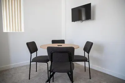a table and chairs with a television on a wall at Balmoral Stays 4 - First Floor in Blackpool