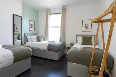a bedroom with two beds and a window at 3 Bed House 9 mins walk to Anfield Sleeps 7 in Liverpool