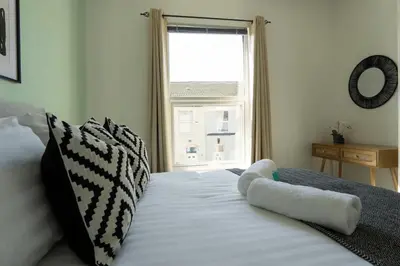a bedroom with a white bed with a window at 3 Bed House 9 mins walk to Anfield Sleeps 7 in Liverpool