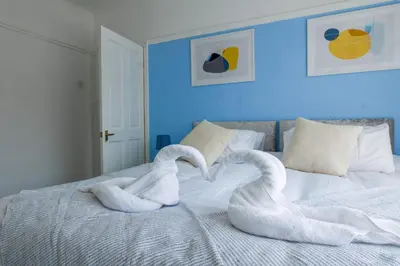 a bed with two swans shaped towels on it at Contractor Stays, Newly Renovated, Free Parking, Sleep 7 in Wallasey