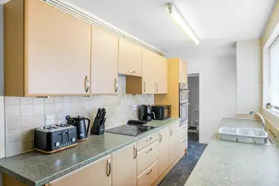 a kitchen with white cabinets and a counter top at Contractor Stays, Newly Renovated, Free Parking, Sleep 7 in Wallasey