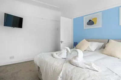 a bedroom with a bed with a towel animal on it at Contractor Stays, Newly Renovated, Free Parking, Sleep 7 in Wallasey