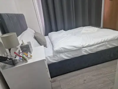 a small bedroom with a bed and a night stand at Sleeps 10- Free Parking- Close To Goodison&Anfield in Liverpool