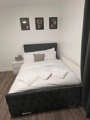 a large bed with a black headboard in a bedroom at Sleeps 10- Free Parking- Close To Goodison&Anfield in Liverpool