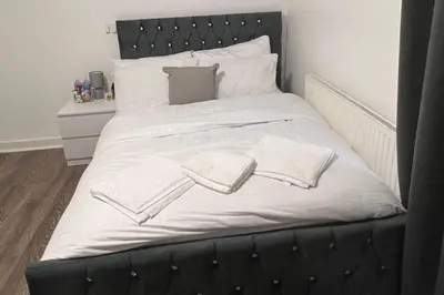 a large black bed with white sheets and pillows at Sleeps 10- Free Parking- Close To Goodison&Anfield in Liverpool