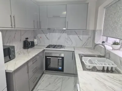 a white kitchen with a stove and a sink at Sleeps 10- Free Parking- Close To Goodison&Anfield in Liverpool