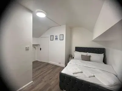 a bedroom with a large bed with a black headboard at Sleeps 10- Free Parking- Close To Goodison&Anfield in Liverpool