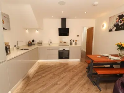 a kitchen with a table and a dining room at Lakes View Apartment 1 in Carnforth