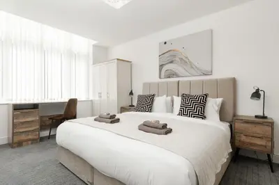 a bedroom with a large white bed with towels on it at Modern unique duplex apartment in town centre in Lytham St Annes