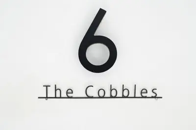 a sign with the number six and the colossias at Modern unique duplex apartment in town centre in Lytham St Annes