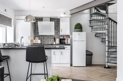 a kitchen with a white refrigerator and a staircase at Modern unique duplex apartment in town centre in Lytham St Annes
