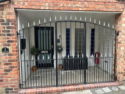 an iron gate in front of a brick building at Modern unique duplex apartment in town centre in Lytham St Annes