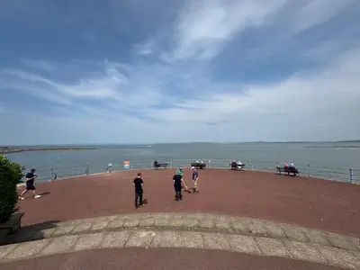 a group of people standing on a pier near the water at Bay Walk Place in Morecambe
