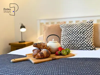 a tray with food and a tea pot on a bed at No 7 PolkaStays Ivy Farm Fern Cottage in Plumpton
