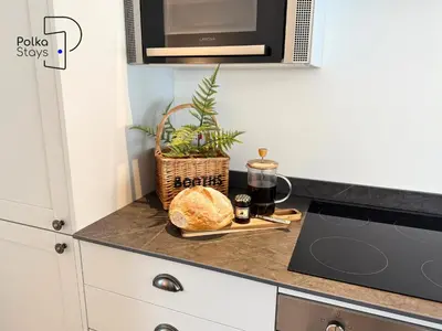 a kitchen counter with a laptop and bread on it at No 7 PolkaStays Ivy Farm Fern Cottage in Plumpton