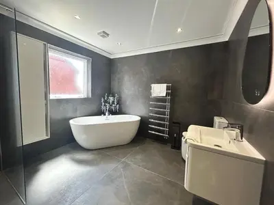 a bathroom with a bath tub and a sink at Stanley House - Luxury 6 Bed, Free Parking in Blackpool