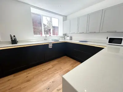 a kitchen with black and white cabinets and a window at Stanley House - Luxury 6 Bed, Free Parking in Blackpool