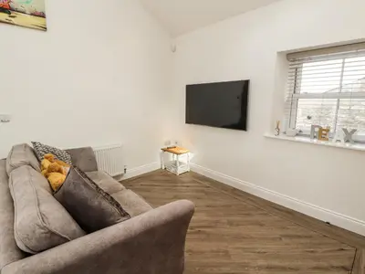 a living room with a couch and a flat screen tv at Lakes View Apartment 2 in Carnforth