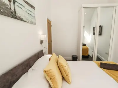 a bedroom with a white bed with two pillows at Lakes View Apartment 2 in Carnforth