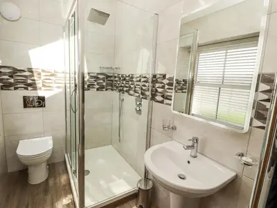 a bathroom with a shower and a toilet and a sink at Lakes View Apartment 2 in Carnforth