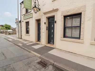 a building with a black door on a street at Lakes View Apartment 2 in Carnforth