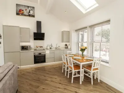 a kitchen and dining room with a table and chairs at Lakes View Apartment 2 in Carnforth