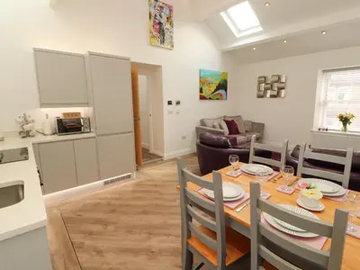 a kitchen and dining room with a table and chairs at Lakes View Apartment 3 in Carnforth