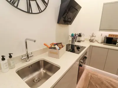 a kitchen with a sink and a clock on the wall at Lakes View Apartment 3 in Carnforth