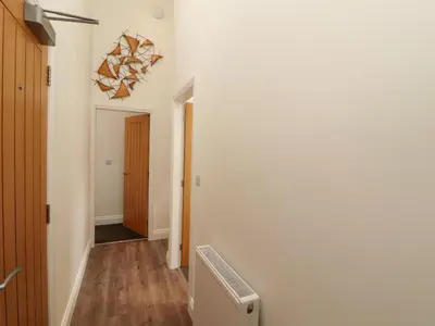 a hallway with a white wall and a radiator at Lakes View Apartment 3 in Carnforth