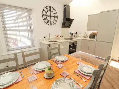 a kitchen and dining room with a wooden table and chairs at Lakes View Apartment 3 in Carnforth