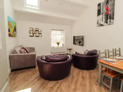 a living room with two couches and a table at Lakes View Apartment 3 in Carnforth