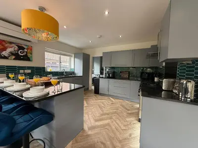 a kitchen with a counter with wine glasses on it at The Hydeaway, Lytham St.Annes House | Free Parking in Lytham St Annes