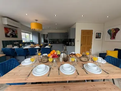 a wooden table with plates and bowls of fruit on it at The Hydeaway, Lytham St.Annes House | Free Parking in Lytham St Annes