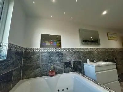 a bathroom with a bath tub and a sink at The Hydeaway, Lytham St.Annes House | Free Parking in Lytham St Annes