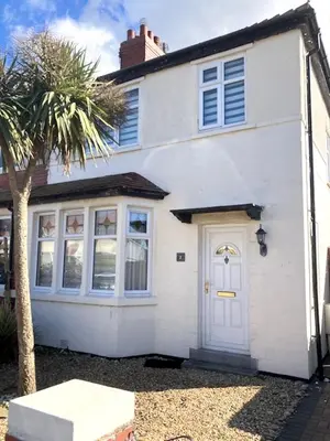 a white house with a white door and a palm tree at Palm House Lytham St Annes in Lytham St Annes
