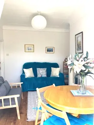 a living room with a blue couch and a table at Palm House Lytham St Annes in Lytham St Annes