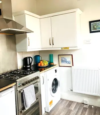 a kitchen with a stove and a washing machine at Palm House Lytham St Annes in Lytham St Annes