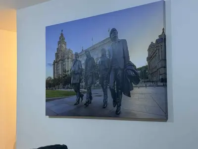 a painting of four men walking on a street at City Centre Apartment in Liverpool